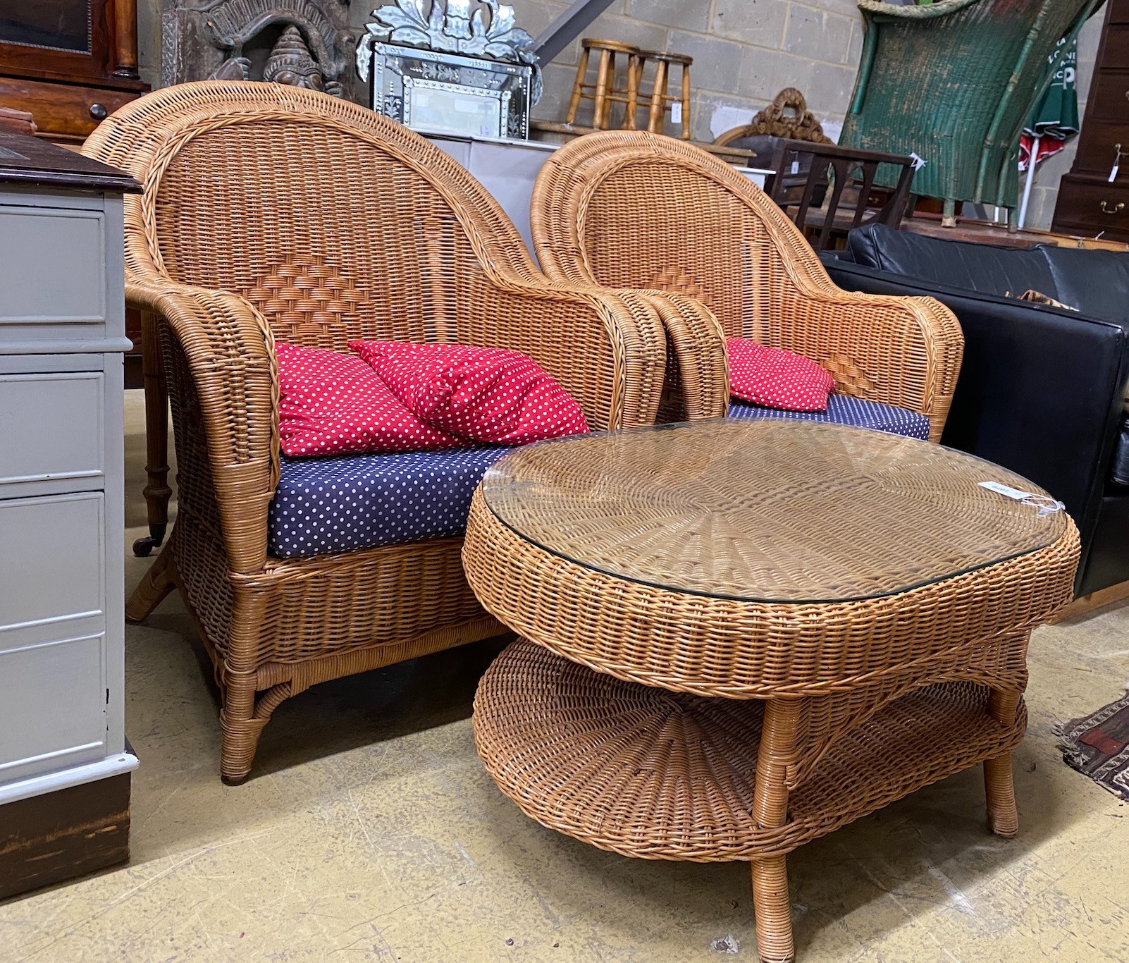 A pair of rattan conservatory chairs and a matching low table